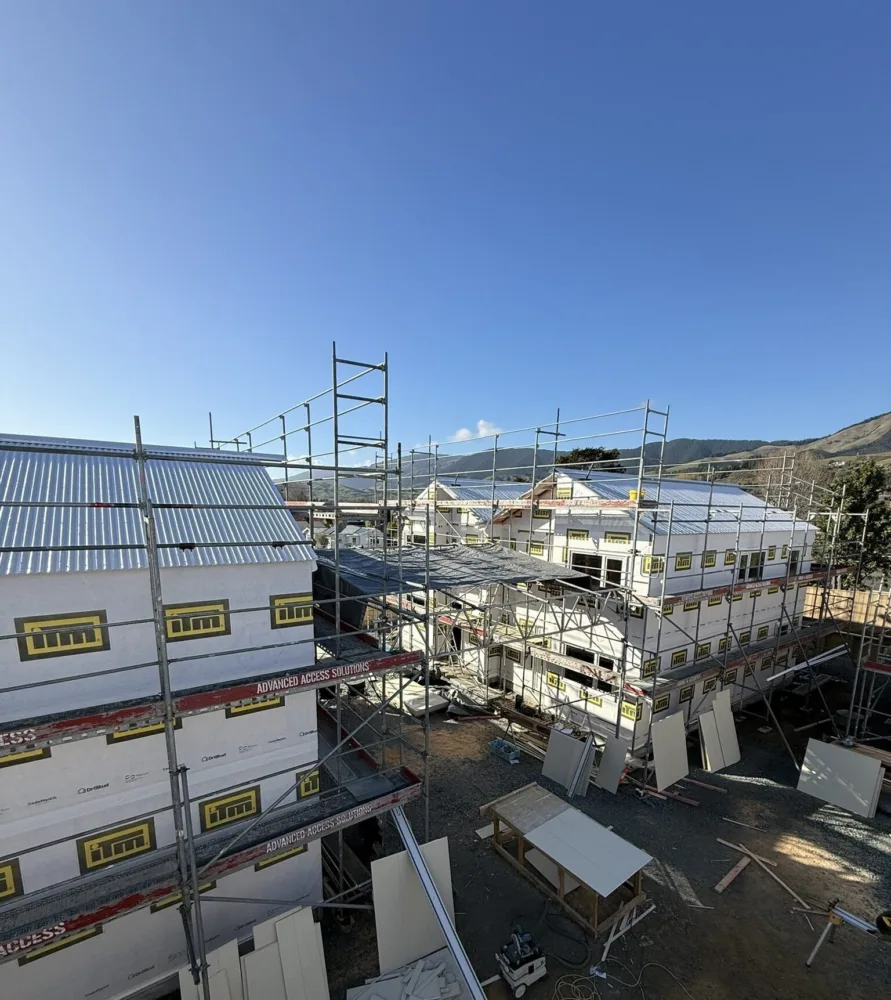 Habitat Nelson’s Richmond housing development, showing townhouses under construction scaffolding on site under a clear blue sky
